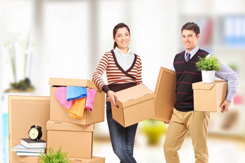 Movers handling fragile household items during packing services in Maidavale